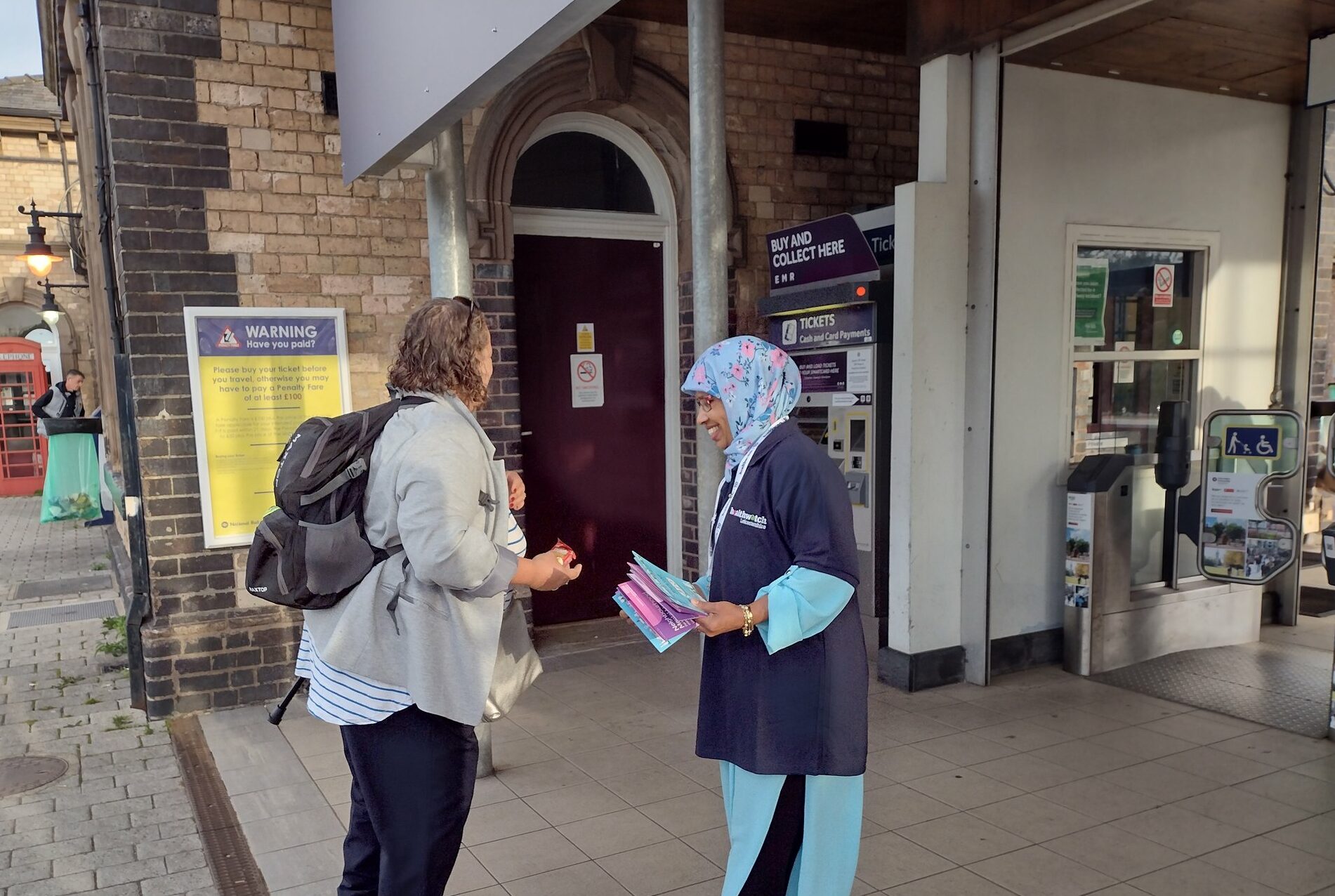 Healthwatch outreach officer speaking to a female member of the public at Loughborough train station